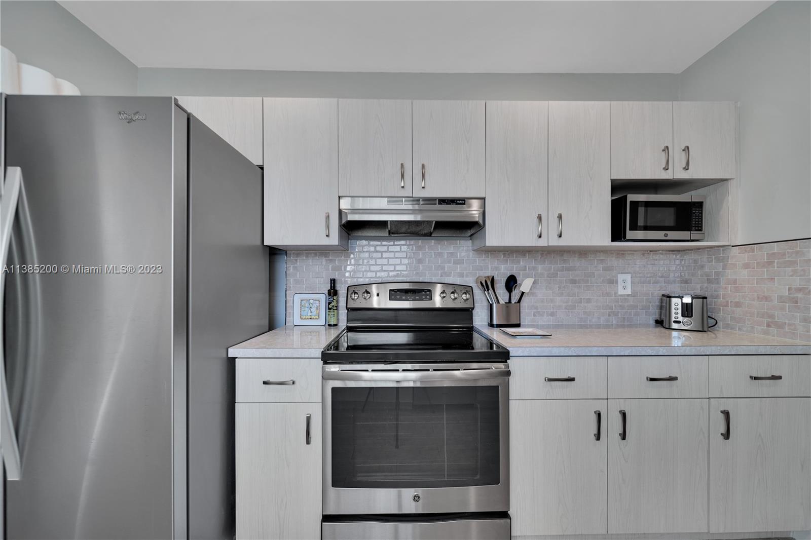 615 Southwest 21st Road Miami, FL 33129 - Photo 31 of 43 a kitchen with stainless steel appliances granite countertop white cabinets a stove a sink and dishwasher