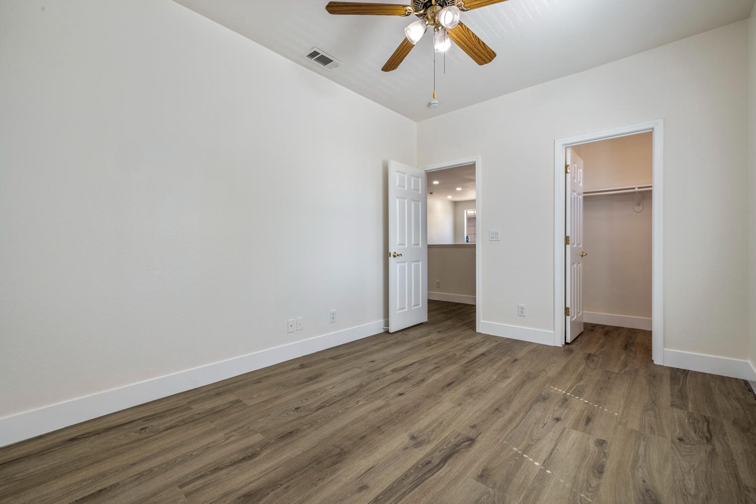 3105 Ripple Court Modesto, CA 95355 - Photo 38 of 46 an empty room with wooden floor chandelier fan and closet area
