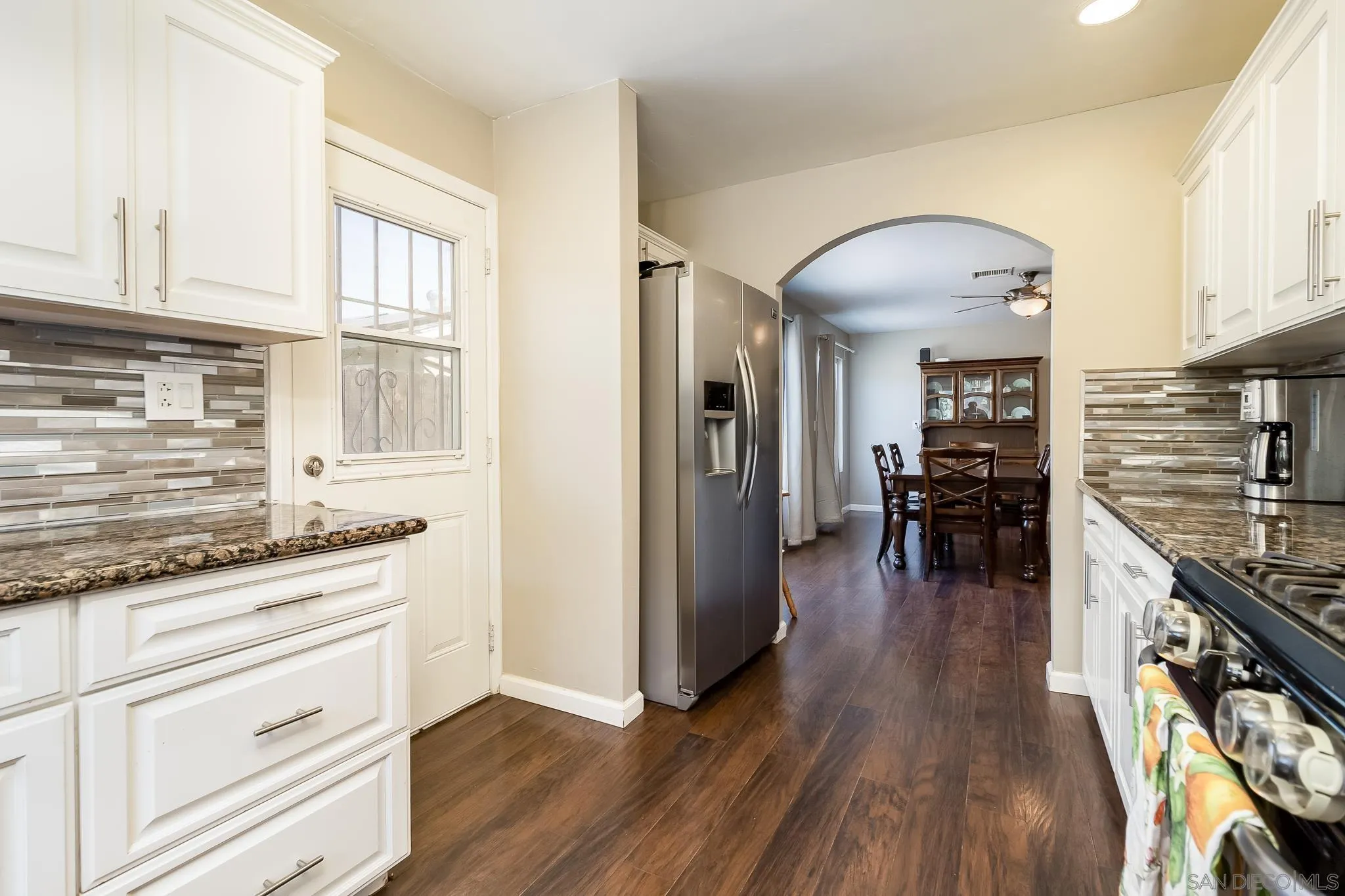 8029 Woodpecker Way Santee, CA 92071 - Photo 14 of 47 a kitchen with granite countertop stainless steel appliances refrigerator wooden floor and cabinets