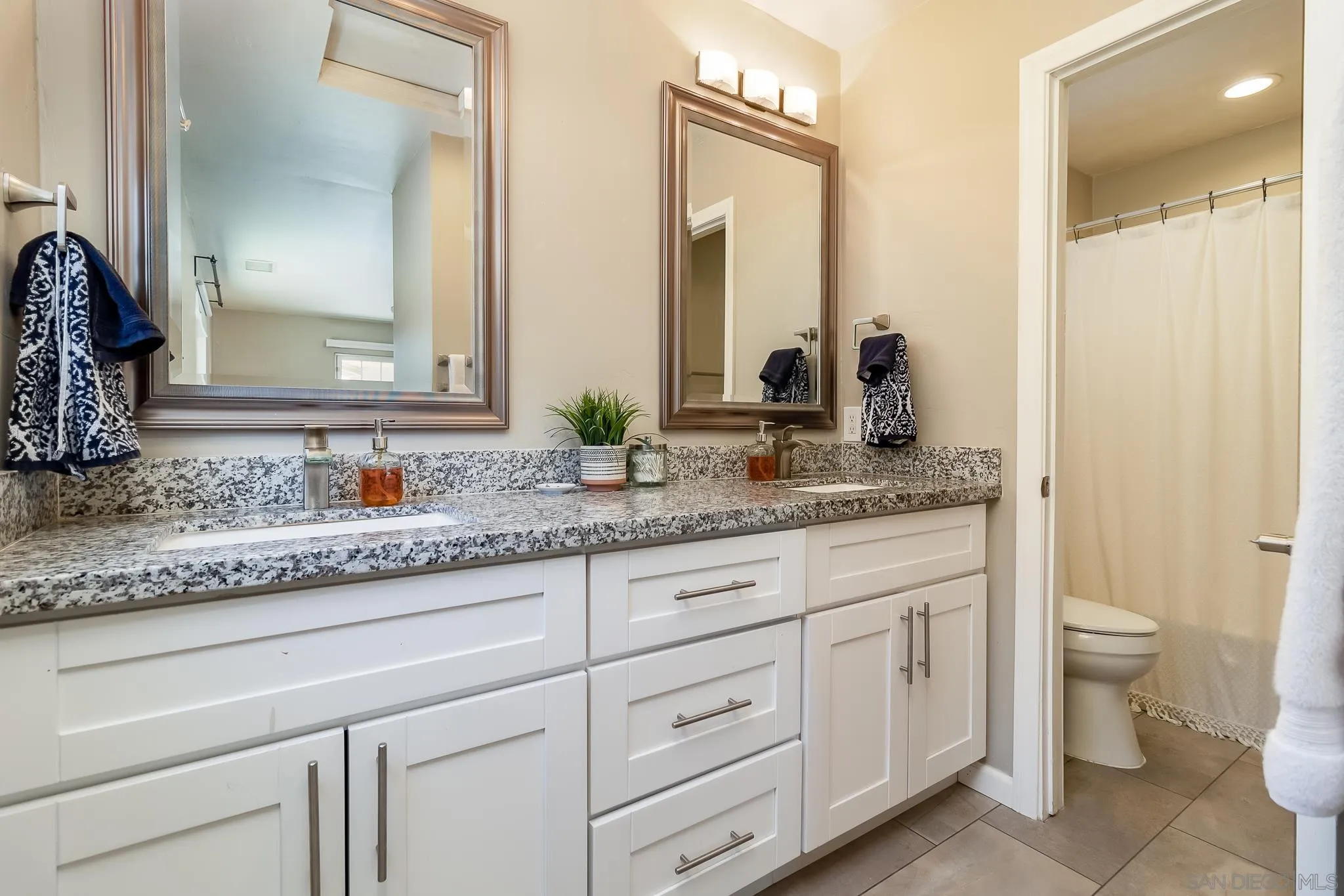 8029 Woodpecker Way Santee, CA 92071 - Photo 18 of 47 a bathroom with a granite countertop sink and a mirror