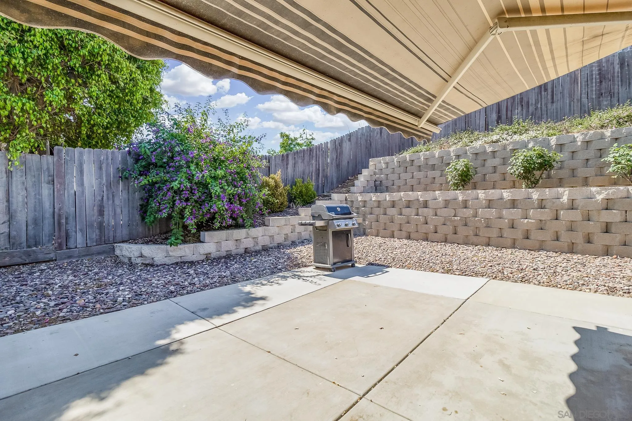 8029 Woodpecker Way Santee, CA 92071 - Photo 25 of 47 a view of a backyard with plants and wooden fence