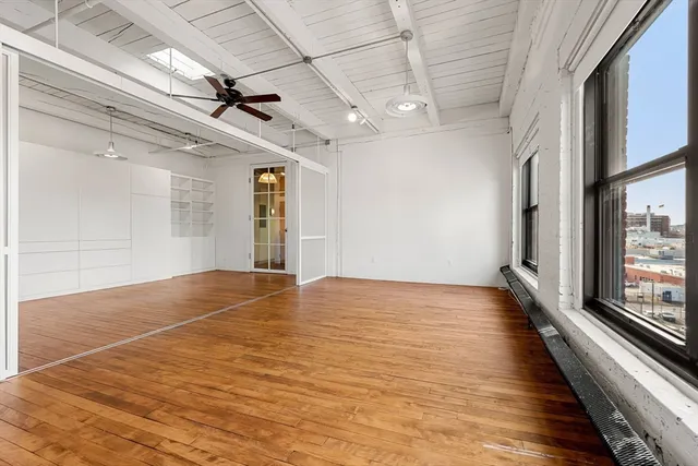 a view of an empty room with wooden floor