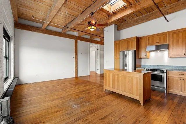 a view of a kitchen with a sink and dishwasher with wooden floor