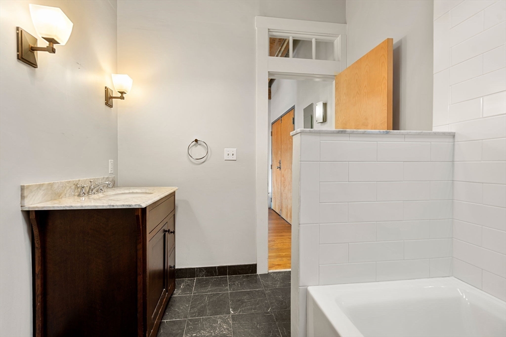 249 A Street, Unit 66 Boston, MA 02210 - Photo 8 of 26 a bathroom with a sink and a mirror