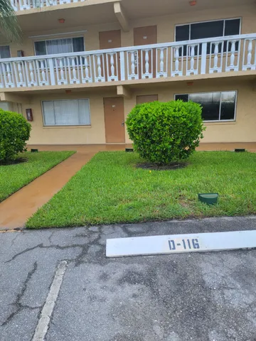 a front view of a house with a yard and potted plants