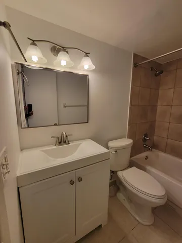 a bathroom with a sink toilet vanity and shower