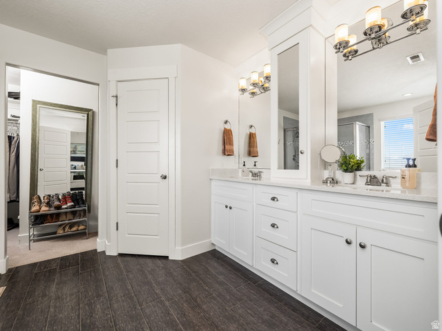 117 Ridge View Drive Elk Ridge, UT 84651 - Photo 19 of 42 Full bath featuring a spacious closet, double vanity, a stall shower, and dark wood finished floors