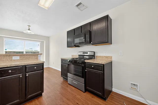 a kitchen with stainless steel appliances and wooden cabinets