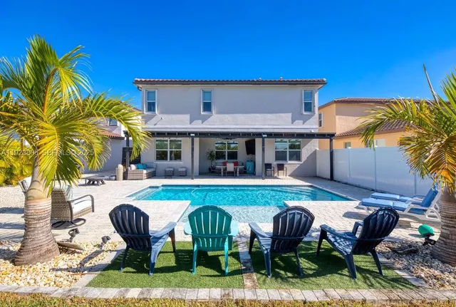 a view of a house with swimming pool and sitting area