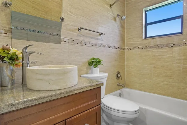 a bathroom with a granite countertop bathtub toilet and sink