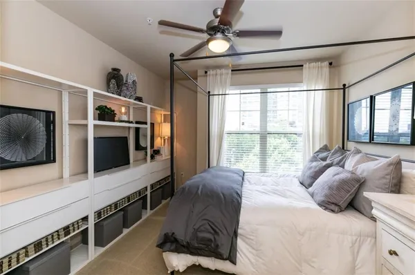 a large bedroom with a large bed a flat tv screen and a walk in closet
