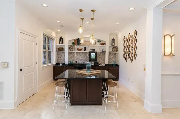 a kitchen with stainless steel appliances kitchen island granite countertop a table and chairs in it