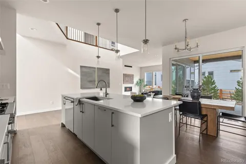 a kitchen with stainless steel appliances granite countertop a sink a stove and a wooden floors