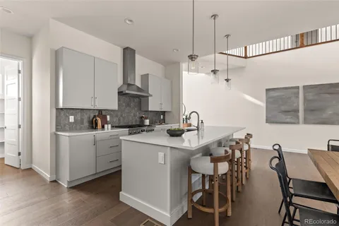 a kitchen that has a sink a table and chairs in it