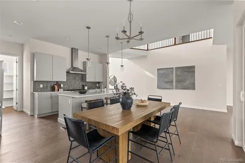 a kitchen with stainless steel appliances a dining table chairs and wooden floor
