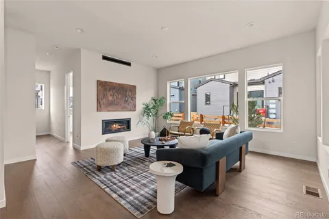 a living room with fireplace furniture and a large window