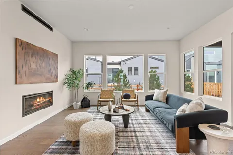 a living room with fireplace furniture and a large window