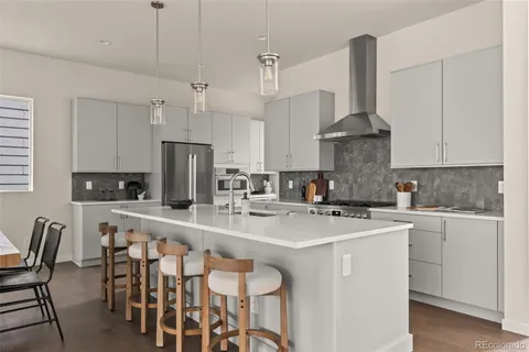 a kitchen with stainless steel appliances a sink a stove a refrigerator a center island and a stove