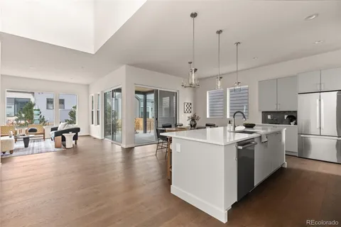 a kitchen with stainless steel appliances kitchen island a white cabinets and wooden floor