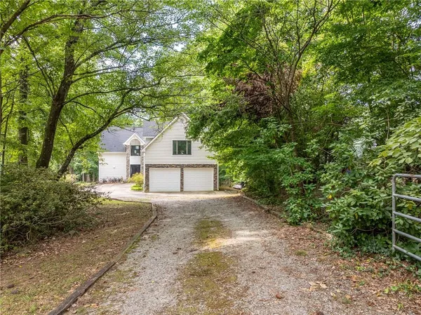 a view of a house with a tree and bushes