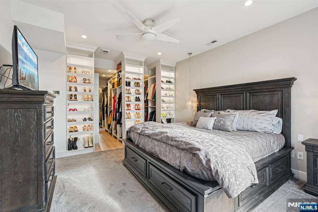 25 Vela Way Edgewater, NJ 07020 - Photo 16 of 41 a bedroom with a large bed a flat tv screen and dresser