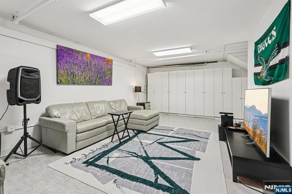 25 Vela Way Edgewater, NJ 07020 - Photo 32 of 41 a living room with furniture and a flat screen tv