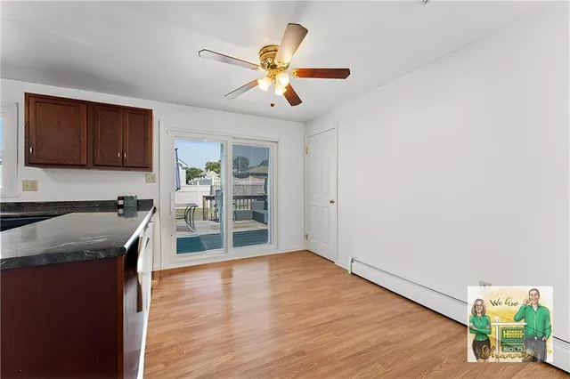 an empty room with wooden floor a ceiling fan and windows