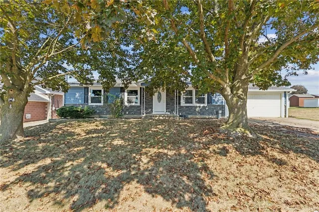 a front view of a house with a tree