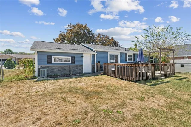 a view of a house with a yard and fence
