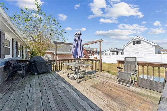 a view of a roof deck with table and chairs with wooden floor and fence