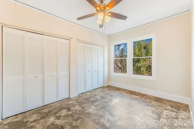 an empty room with windows and closet