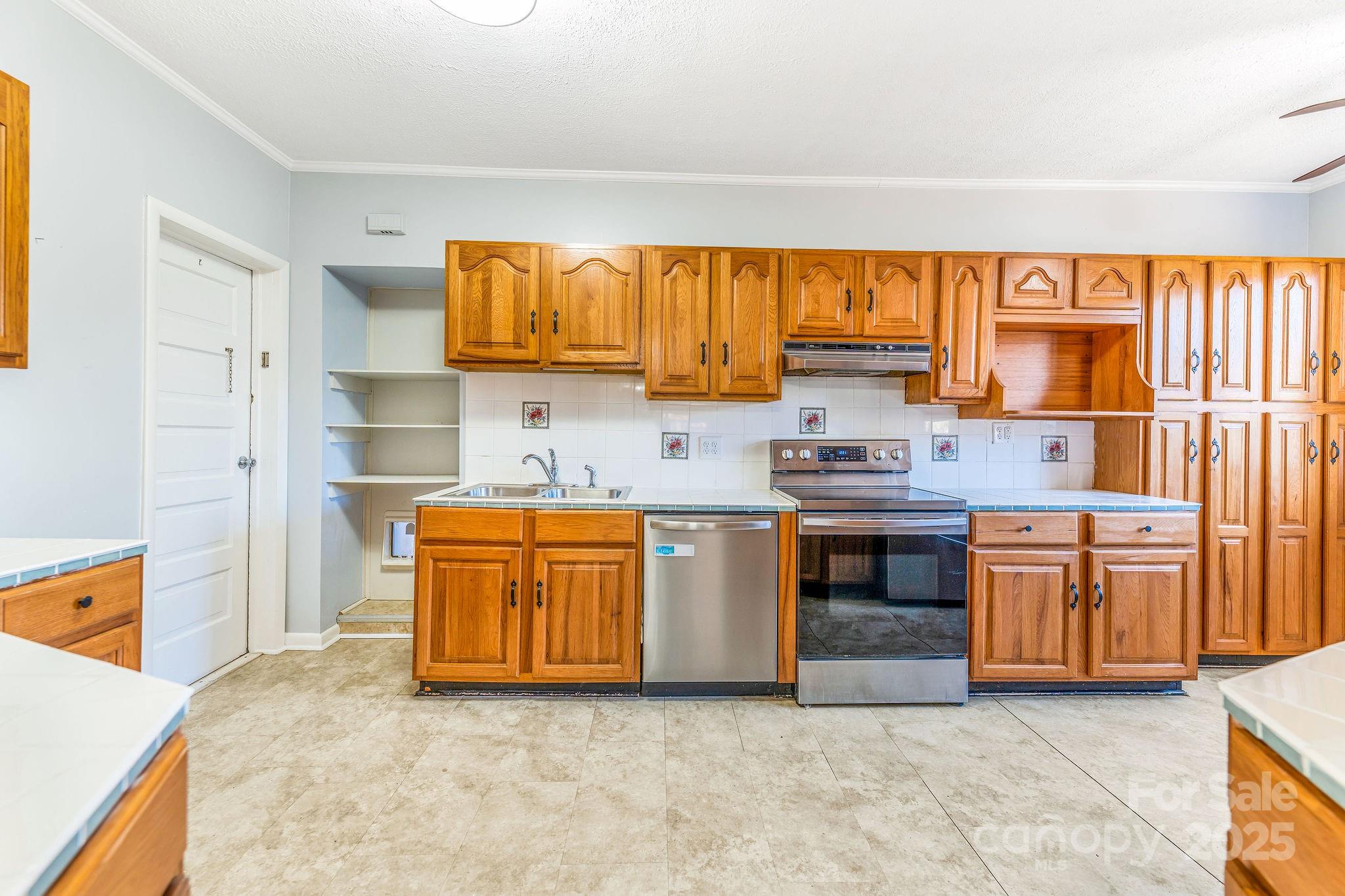 107 Woodland Church Road Clyde, NC 28721 - Photo 14 of 42 a kitchen with stainless steel appliances granite countertop a stove a sink and a refrigerator