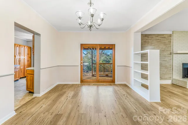 a view of a big room with wooden floor and windows