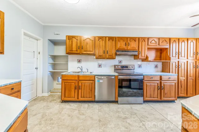 a kitchen with stainless steel appliances granite countertop a stove a sink and a refrigerator
