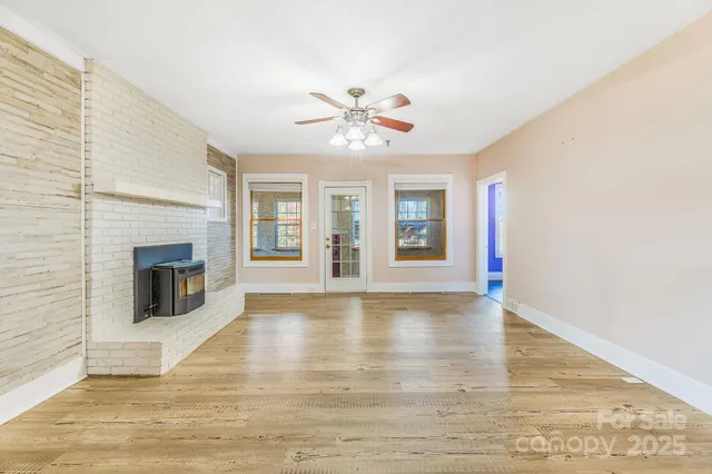 a view of an empty room with window and fireplace