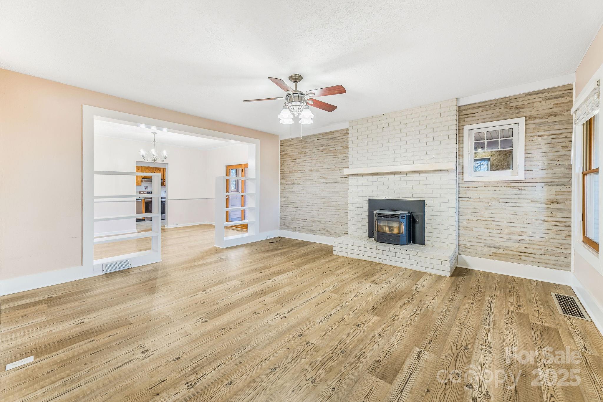 107 Woodland Church Road Clyde, NC 28721 - Photo 20 of 42 a view of a livingroom with wooden floor a fireplace and windows