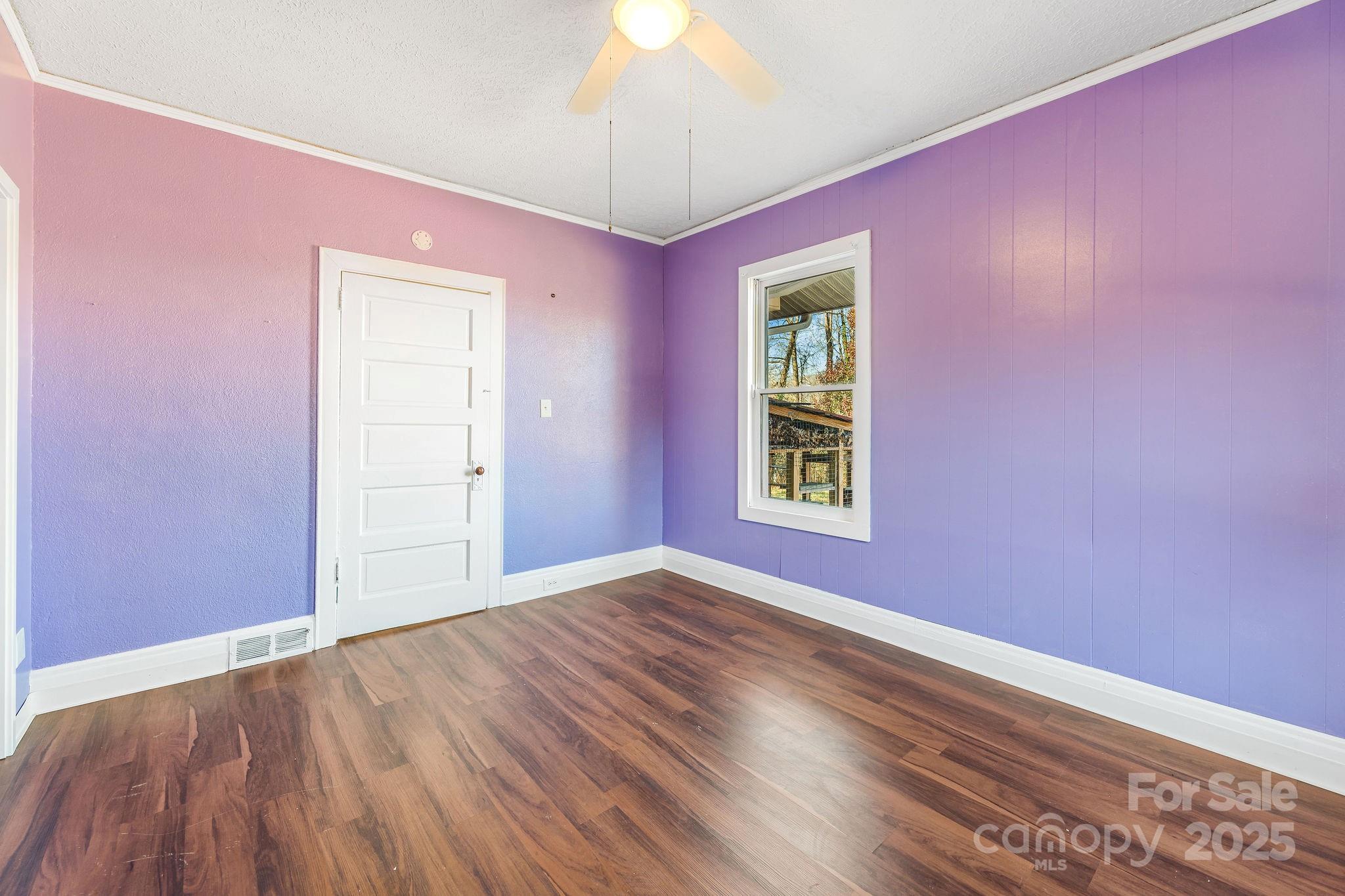 107 Woodland Church Road Clyde, NC 28721 - Photo 21 of 42 a view of empty room with wooden floor and fan