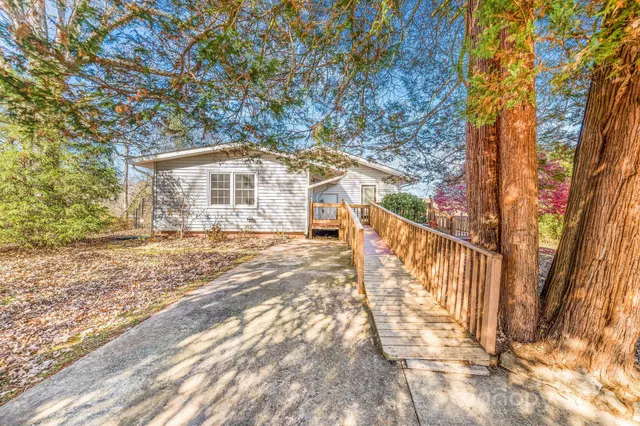a front view of a house with a yard covered with snow and trees