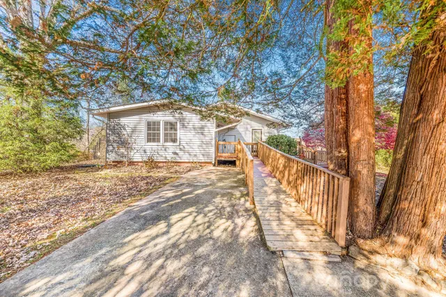 a front view of a house with a yard covered with snow and trees
