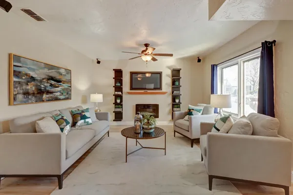 a living room with furniture a fireplace and a large window