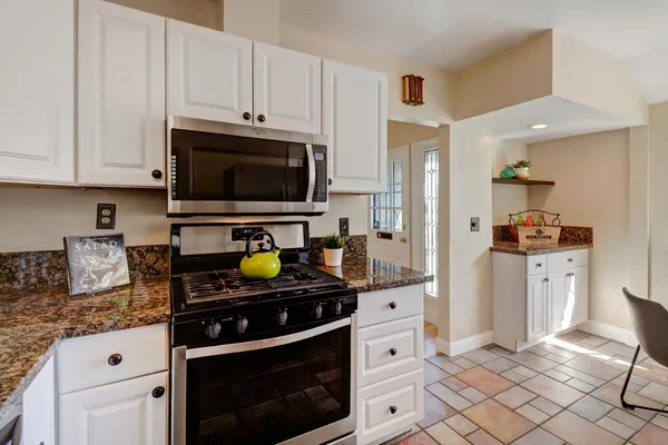 a kitchen with stainless steel appliances a stove a sink and cabinets