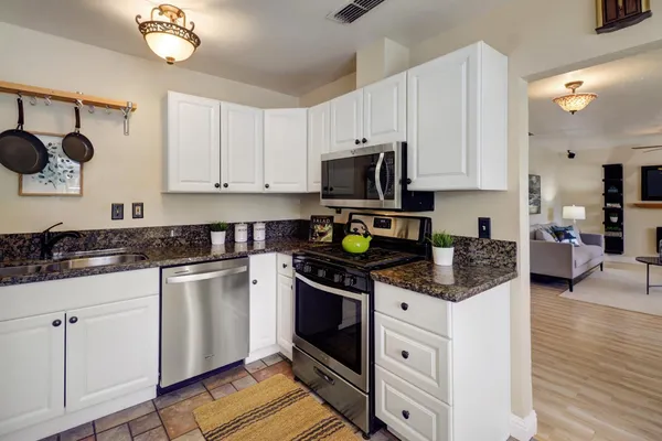 a kitchen with white cabinets and appliances