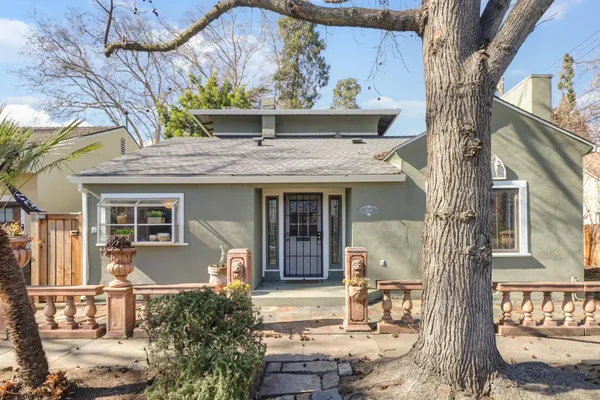 a front view of a house with a tree
