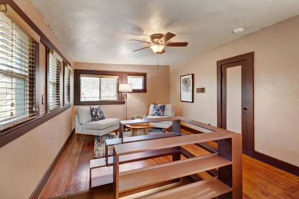 a living room with furniture a table and wooden floor