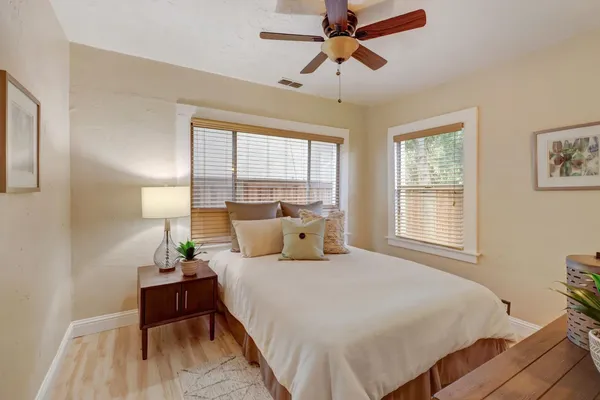 a bedroom with a bed a chandelier and a window