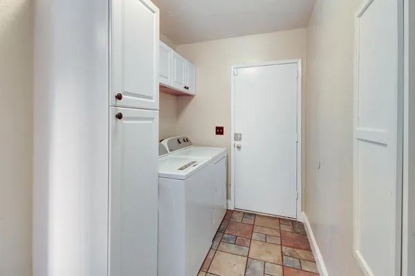 a utility room with cabinets washer and dryer