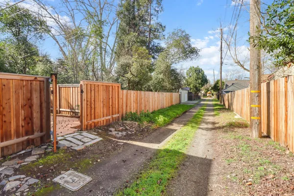 a view of a backyard with wooden fence and a bench