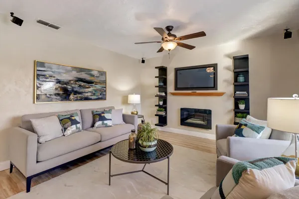 a living room with furniture a fireplace and a flat screen tv