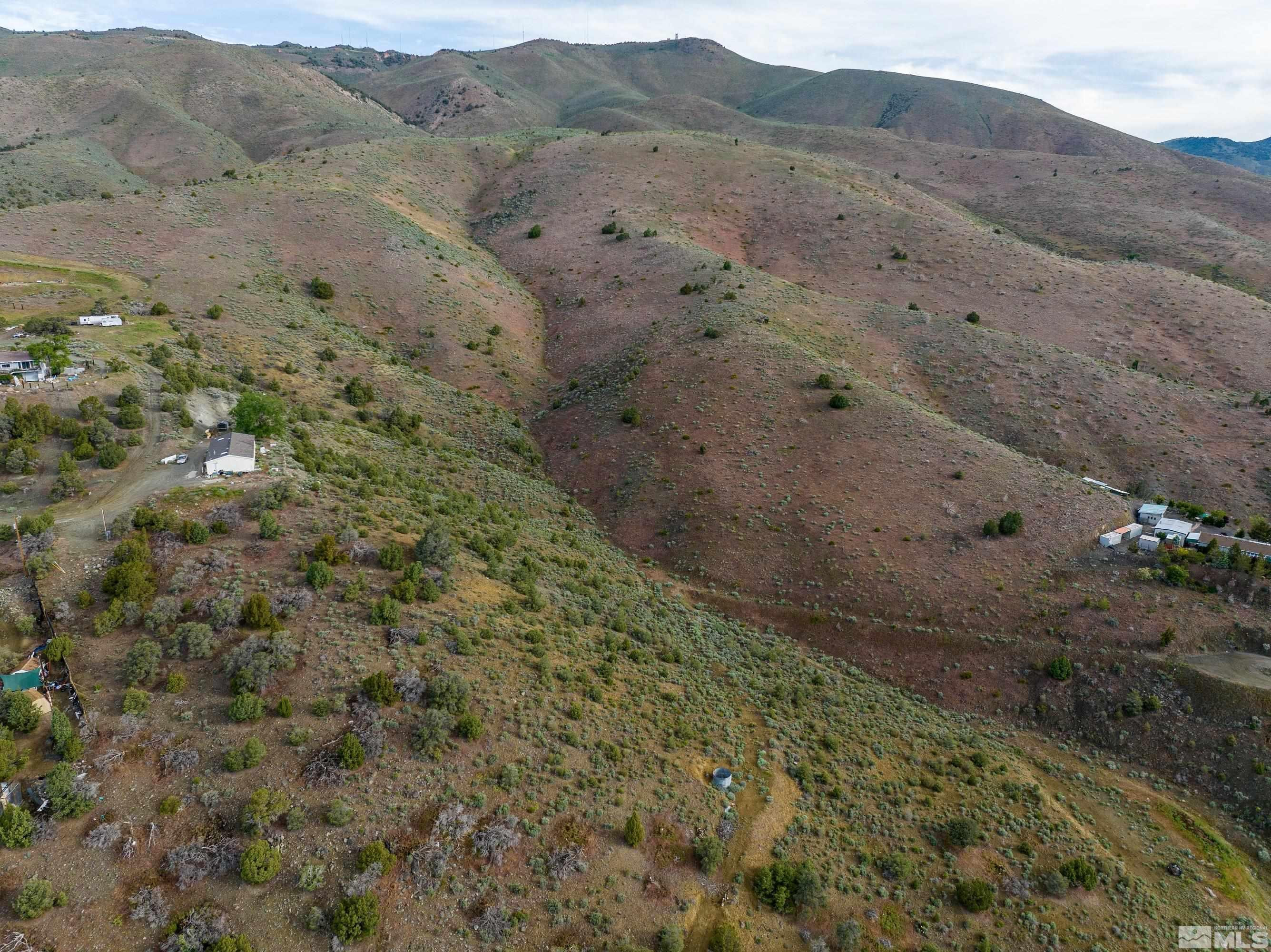 a view of a dry yard with mountains in the background