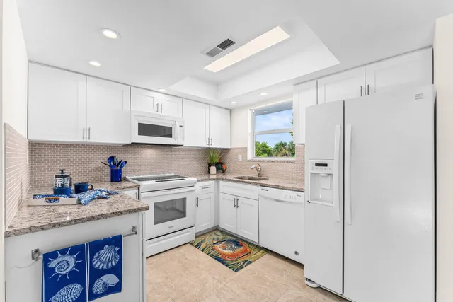 a kitchen with a sink stainless steel appliances and white cabinets